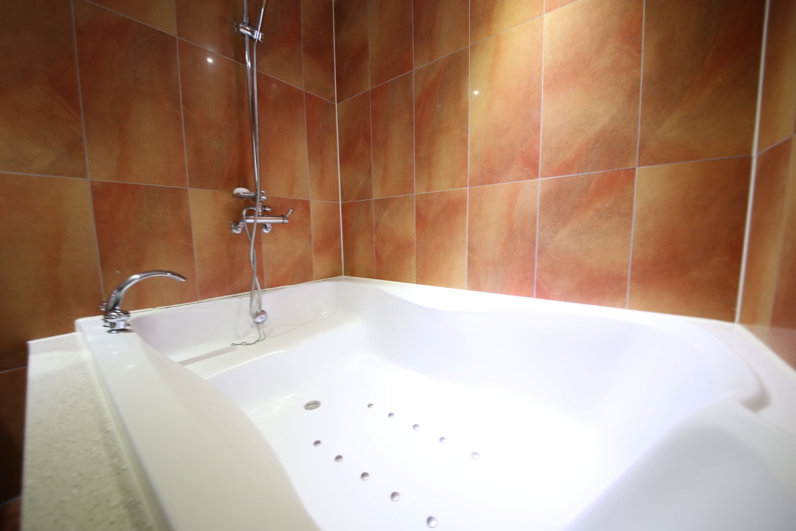 Un baño moderno con una bañera independiente, un cabezal de ducha y un grifo empotrado.