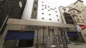 Hotel con señalización que indica que está abierto, con un diseño arquitectónico moderno y un llamativo letrero 'Xian'.