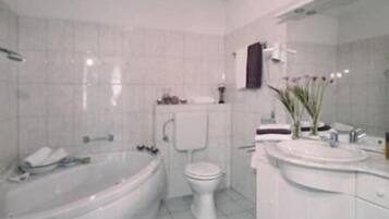 Un baño con bañera, inodoro y lavamanos.
