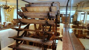 A room with a large wooden structure, possibly a piece of furniture or a decorative element, and a glass partition.