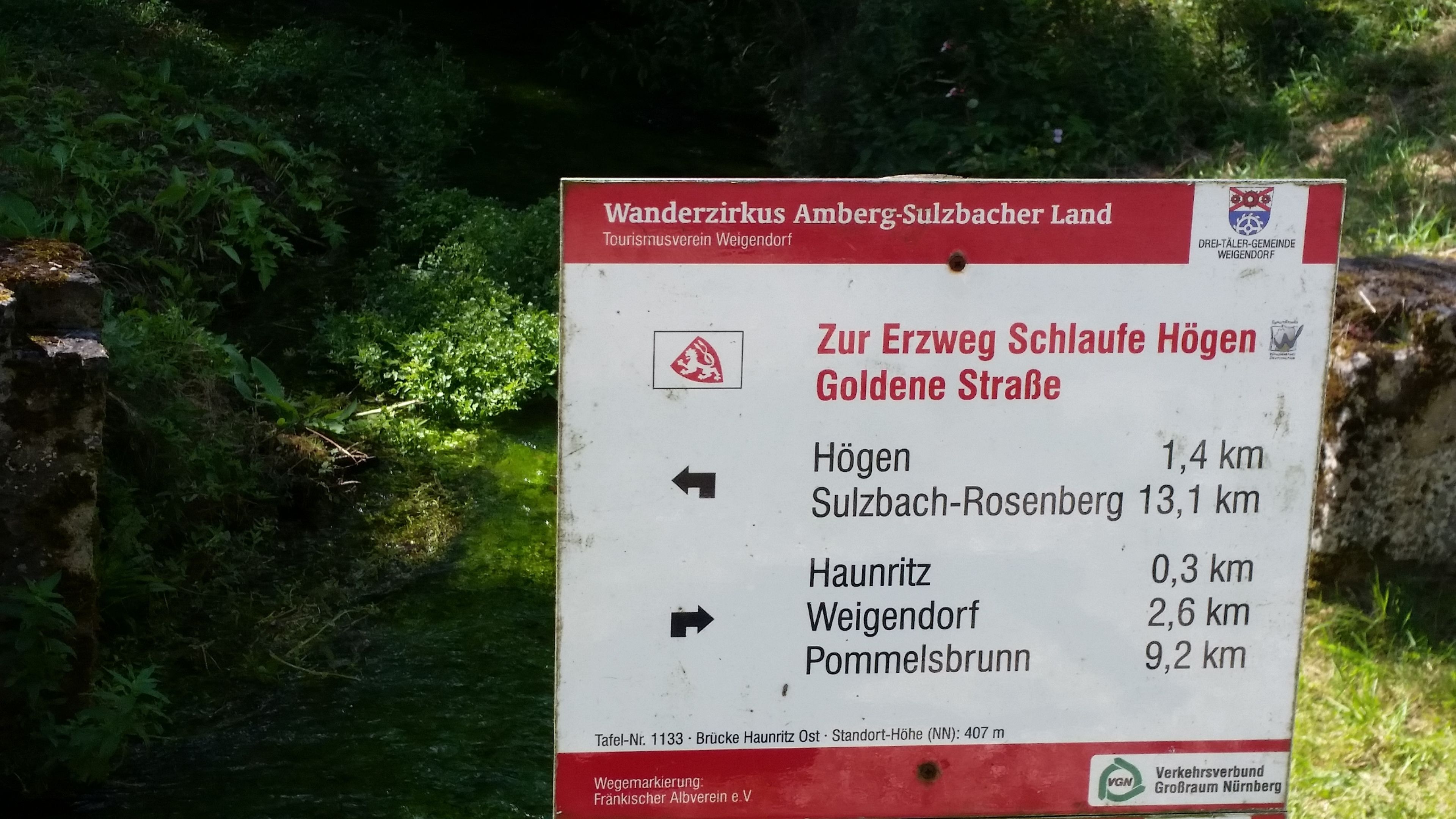 Señal direccional para Wanderzirkus Amber-Sulzbacher Land con distancias a varios destinos.