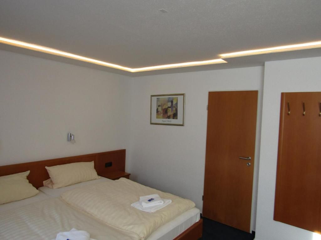 Une chambre d’hôtel avec un lit, une armoire en bois et un tableau au mur.