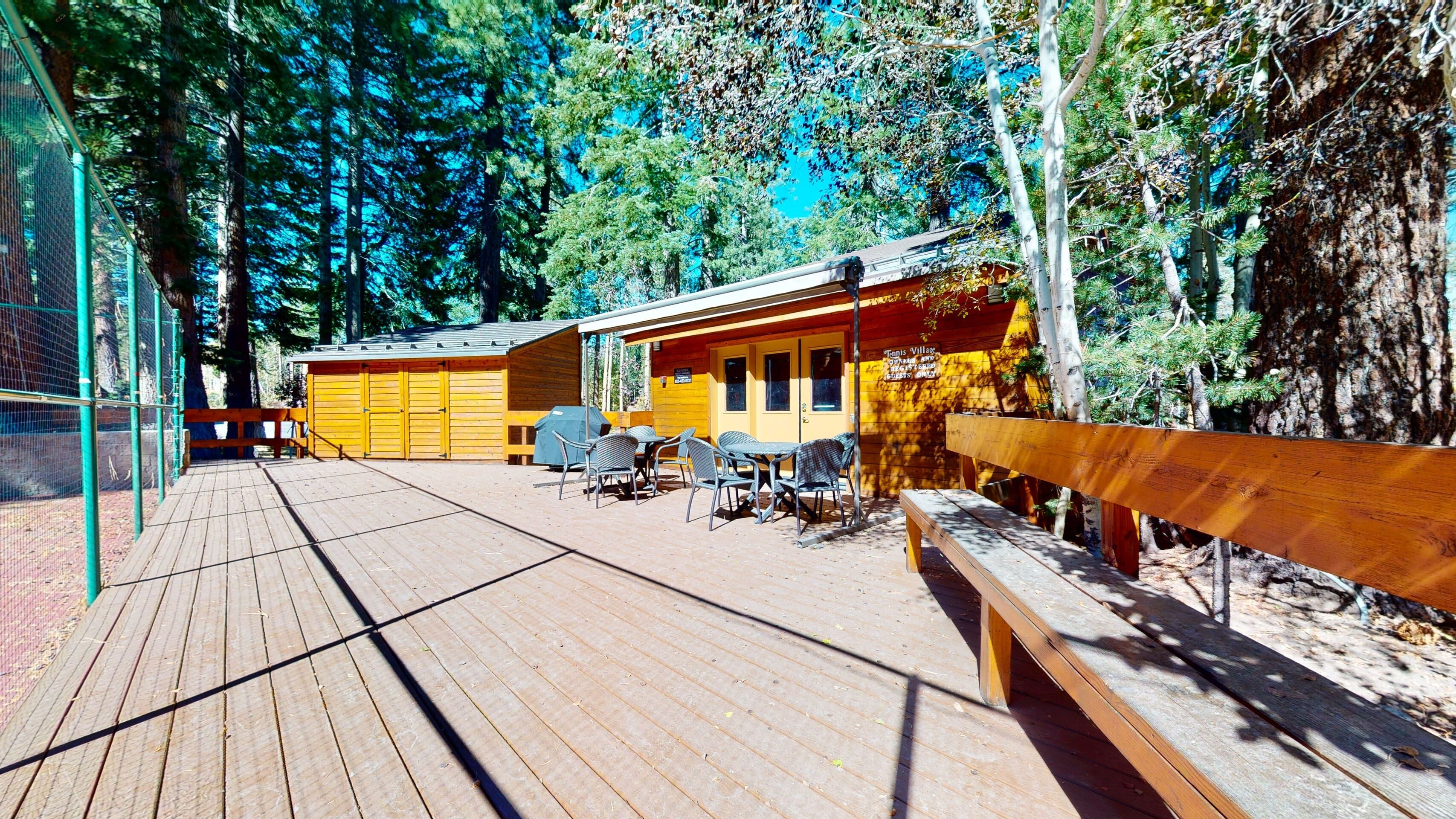 A wooden deck with outdoor seating and a wooden bench.
