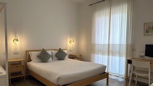 A bedroom with a wooden bed, two bedside tables, a desk, and a chair. - NG Guest House l'Acquedotto (Olbia)