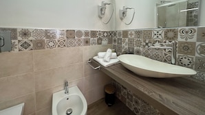 A bathroom with a large sink, a bidet, and a mirror. - NG Guest House l'Acquedotto (Olbia)