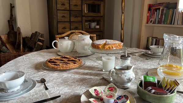 A dining table with a variety of food items, including a pie, a jug of milk, and a pitcher. - La Fratta Art - House (Marsciano)