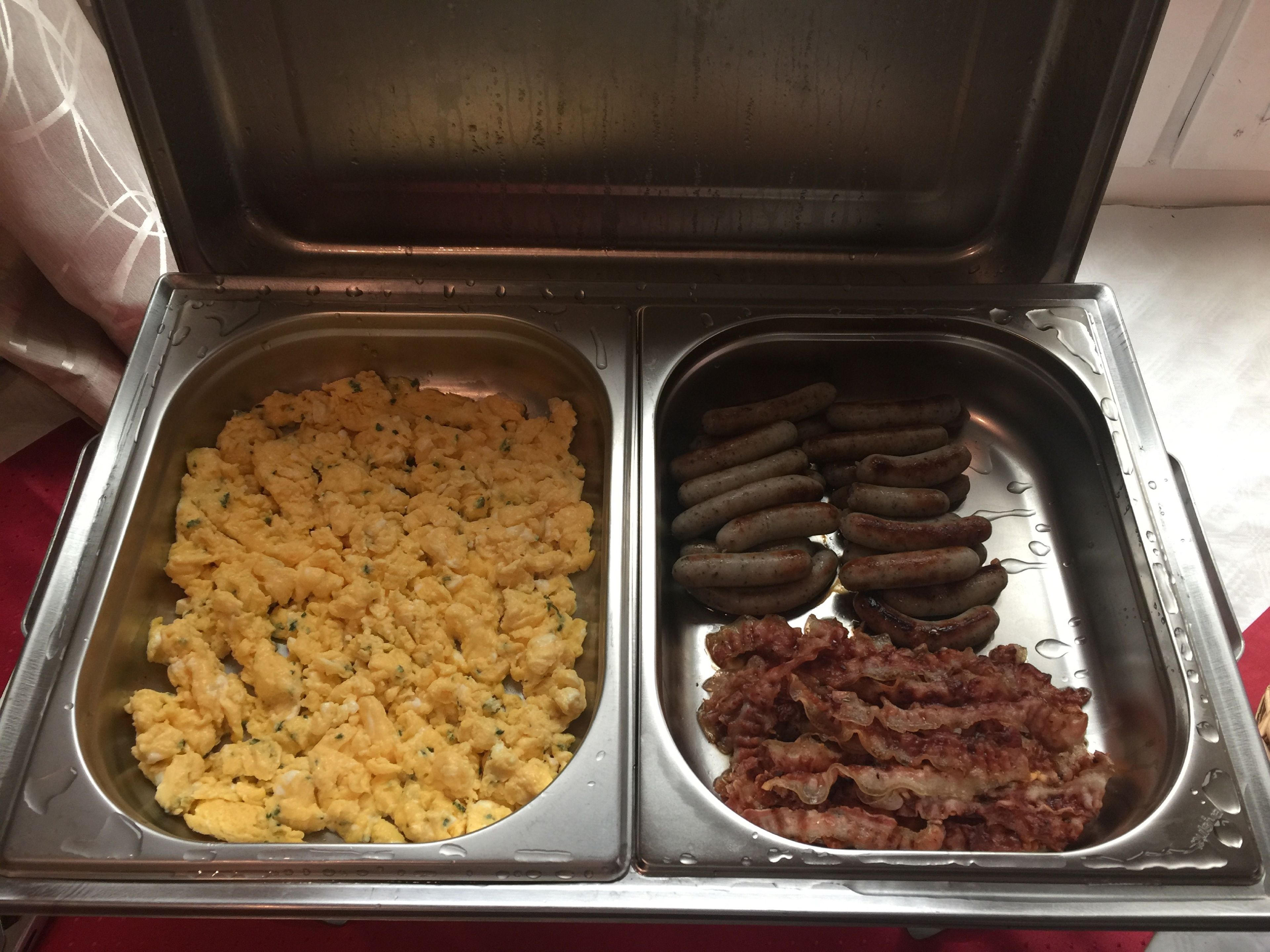 Ein Buffet mit Rührei und Würstchen.