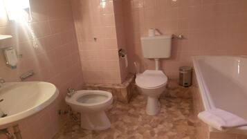 Un baño con lavamanos, inodoro y bañera.