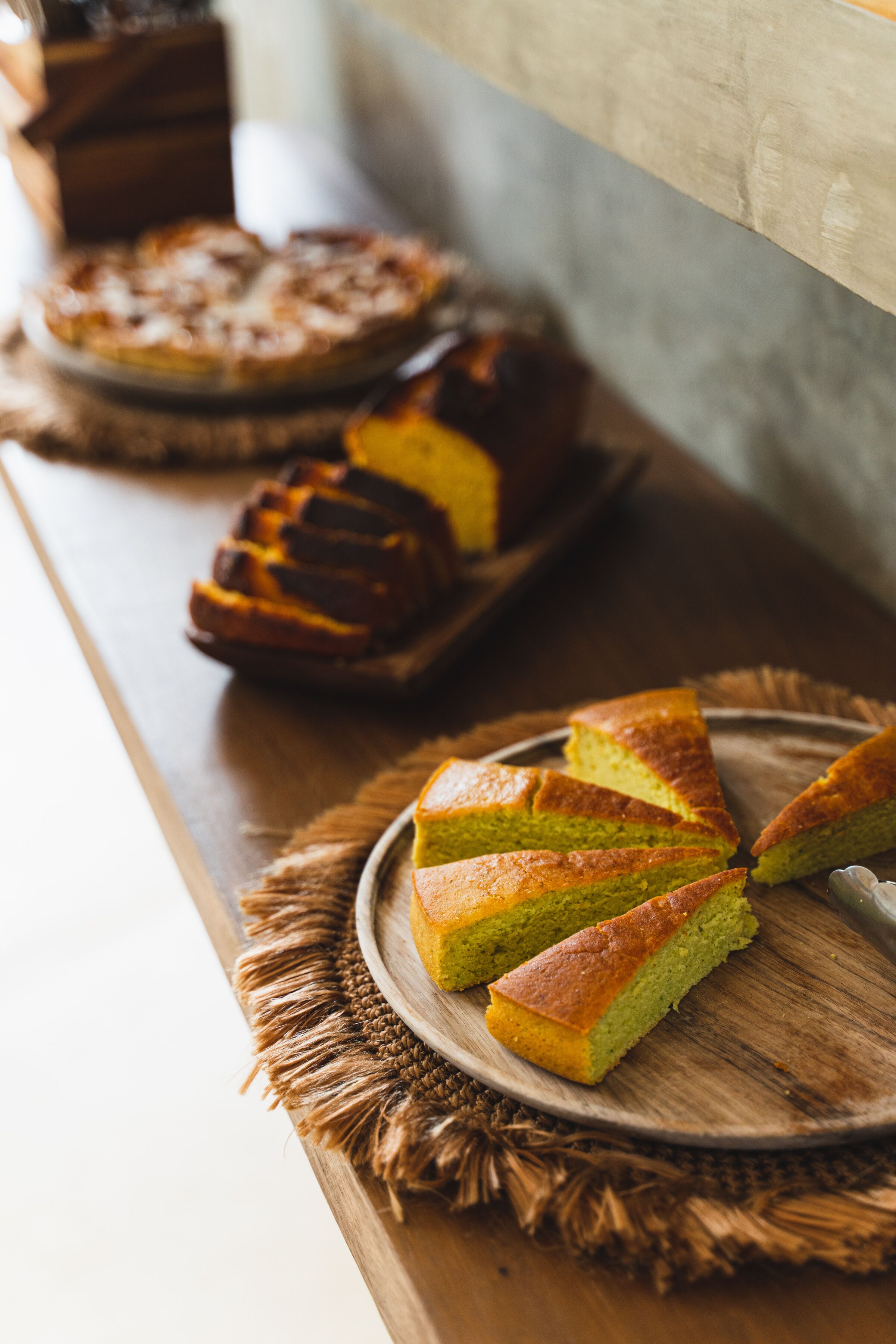 A wooden table with a cake and a pie on it.