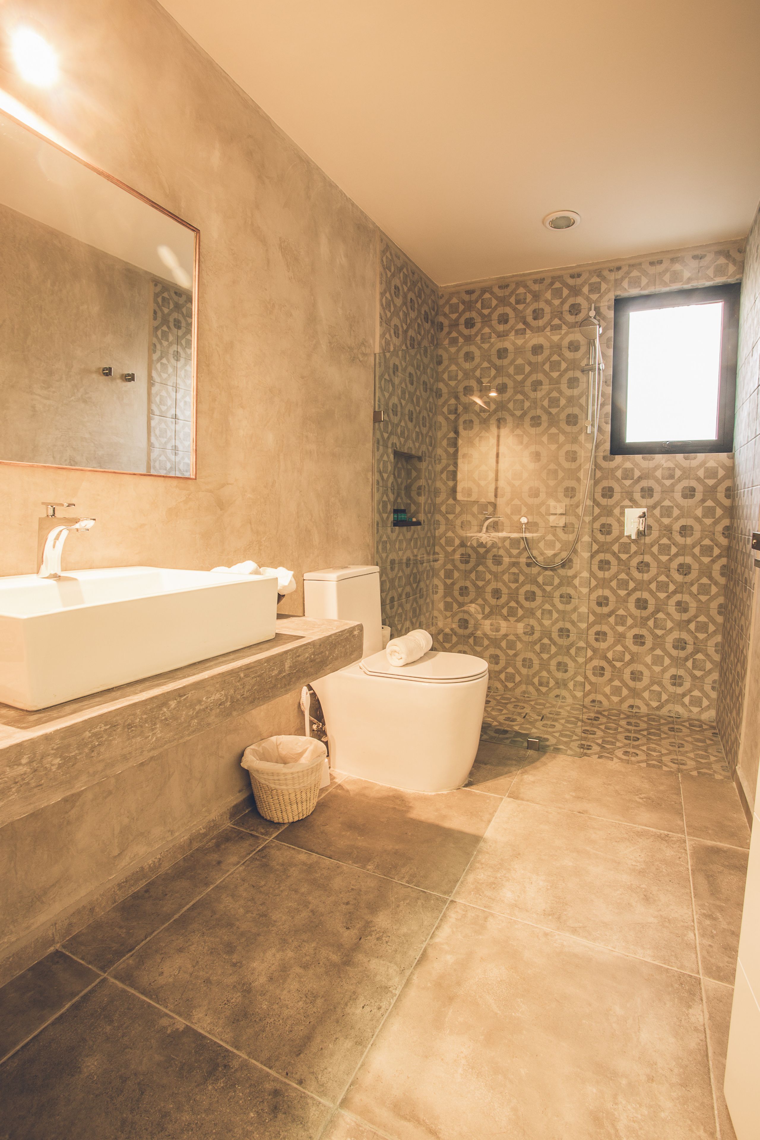 A bathroom with a large sink, toilet, and shower area.