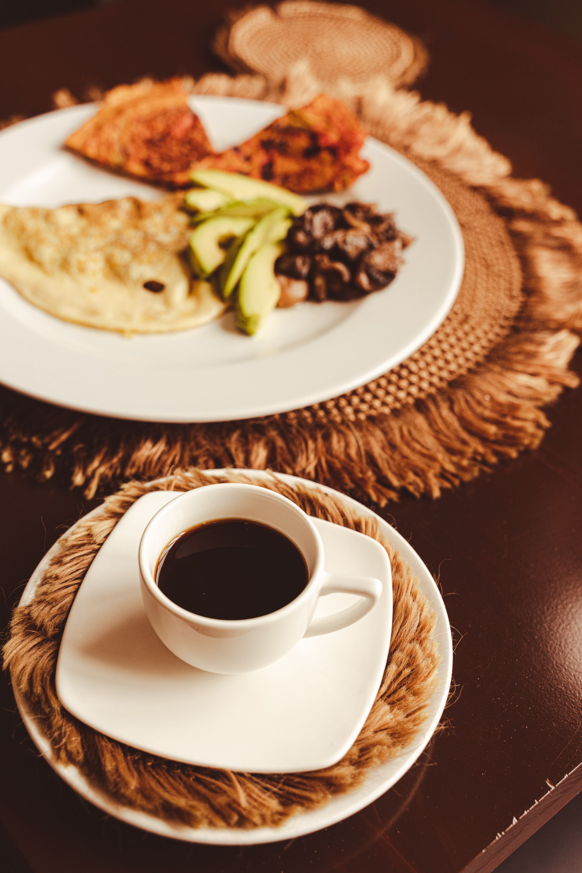 Un tavolo con un piatto di cibo e una tazza di caffè.