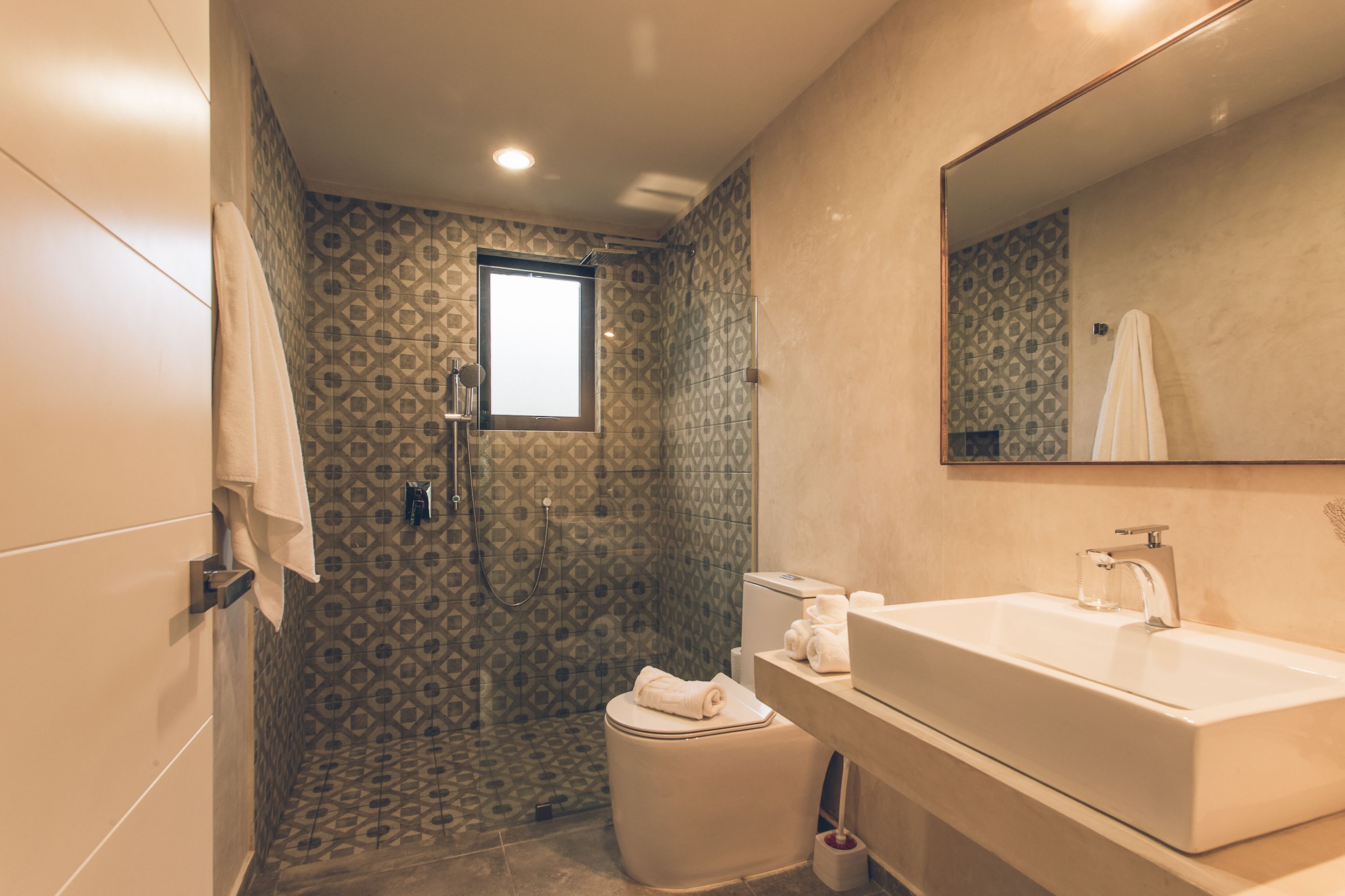 Un baño moderno con ducha, inodoro y lavamanos.