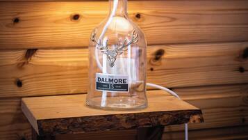 A lamp with a plaid lampshade on a wooden table.