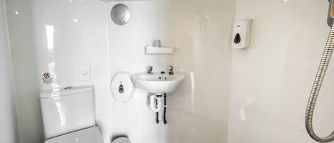A modern bathroom with a toilet, sink, and shower.