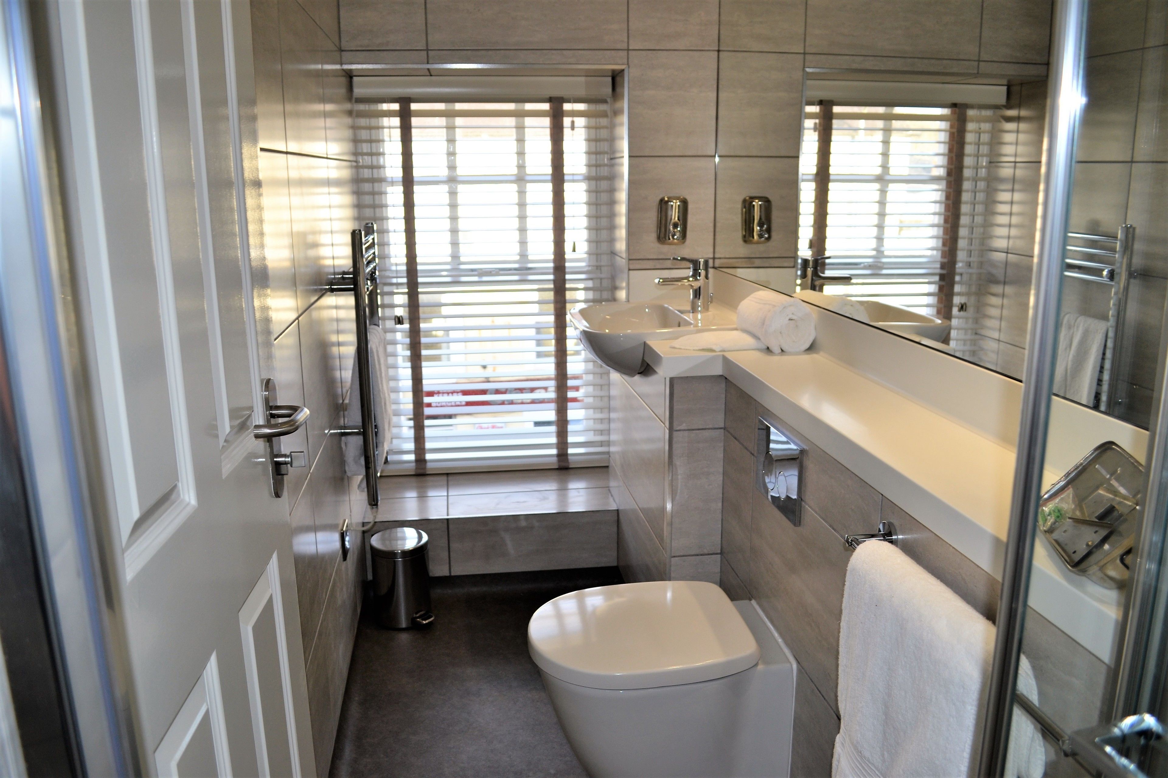 A modern bathroom with a toilet, sink, and glass shower enclosure.