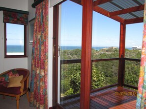 A wooden balcony with a view of the ocean and greenery. - Melkhoutkloof Guest House (Glentana)