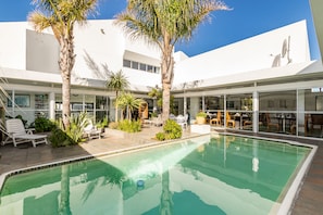 Una piscina al aire libre, tumbonas