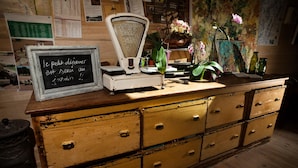 A vintage wooden dresser with multiple drawers, a vintage scale, and a chalkboard sign. - Le Clos de l'Abbaye (Cluny)