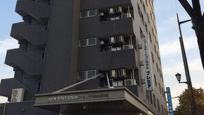 A multi-story hotel with a modern design, featuring a prominent entrance and multiple balconies. - New Station Hotel Premiere (Isahaya)