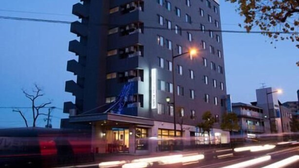 A multi-story hotel with a modern design, featuring a prominent entrance and a sign indicating it is a hotel. - New Station Hotel Premiere (Isahaya)