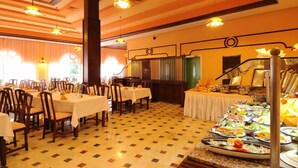 A dining area with tables set for service, a buffet with various dishes, and a staircase leading to an upper level. - Dar Ismail Nour Elain (Ain Draham)
