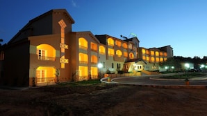A multi-story hotel with a central courtyard, balconies, and a well-lit facade. - Dar Ismail Nour Elain (Ain Draham)
