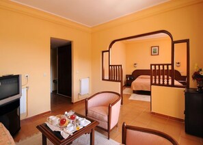 Minibar, escritorio, cortinas blackout y tabla de planchar con plancha