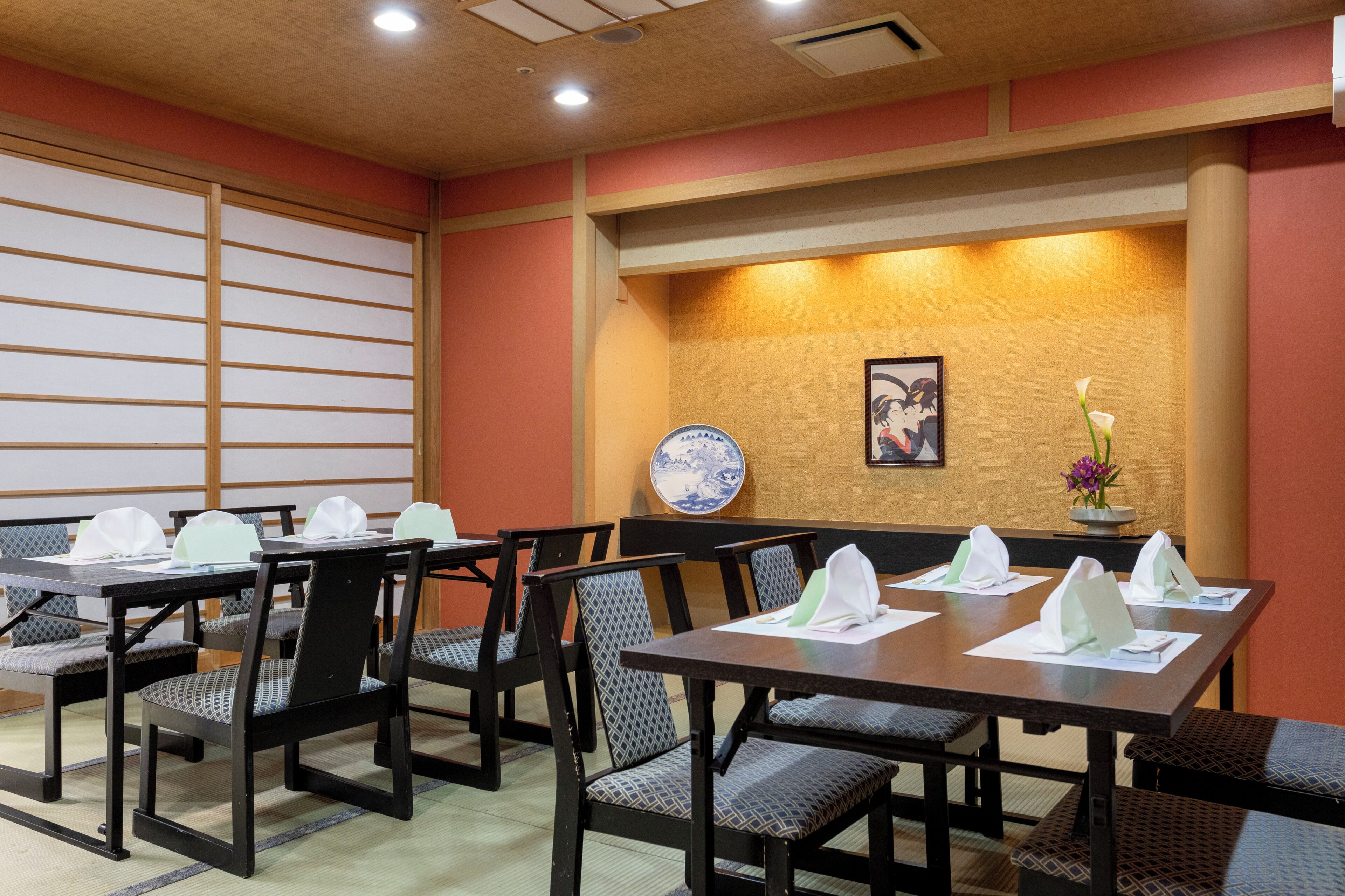 A dining area with tables, chairs, and a decorative wall.