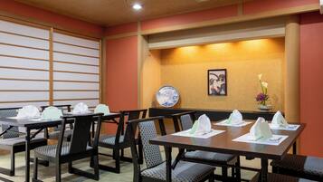 A dining area with tables, chairs, and a decorative wall.