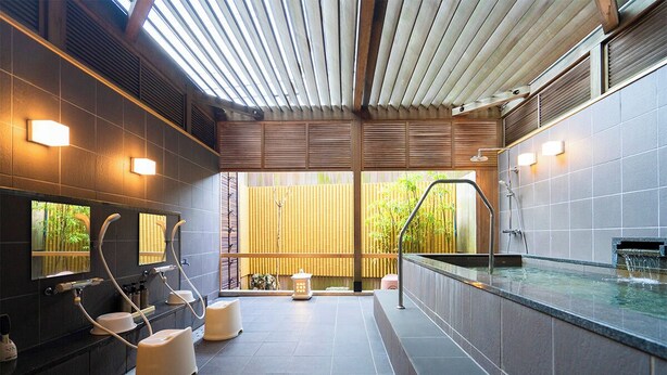 Ein moderner Wellnessbereich mit Whirlpool, Sitzgelegenheiten und einem großen Spiegel.