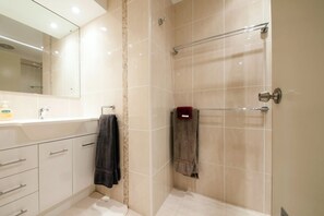 Ein modernes Badezimmer mit Dusche, Waschbecken und Spiegel.