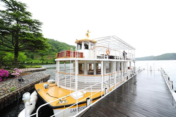 Un barco de paseo fluvial con cubierta superior protegida, zona de camarotes y cubierta de madera.