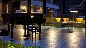 An outdoor area with a piano, chairs, and large windows. - Hotel Suigekka (Wakasa)