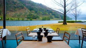 A table set for dining with a view of a lake and hills. - Hotel Suigekka (Wakasa)