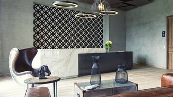 A modern lobby with a reception desk, leather seating, and decorative vases.