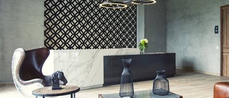 A modern lobby with a reception desk, leather seating, and decorative vases.