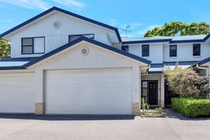 Un immeuble résidentiel de deux étages, doté d’un garage et d’une allée.