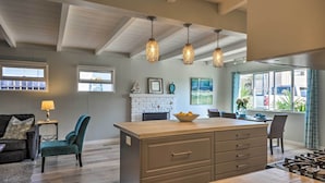 A spacious living area with a wooden island, a fireplace, and a dining area with a view. - Remodeled Ventura Beach Home with Yard & Fire Pit! (Ventura)