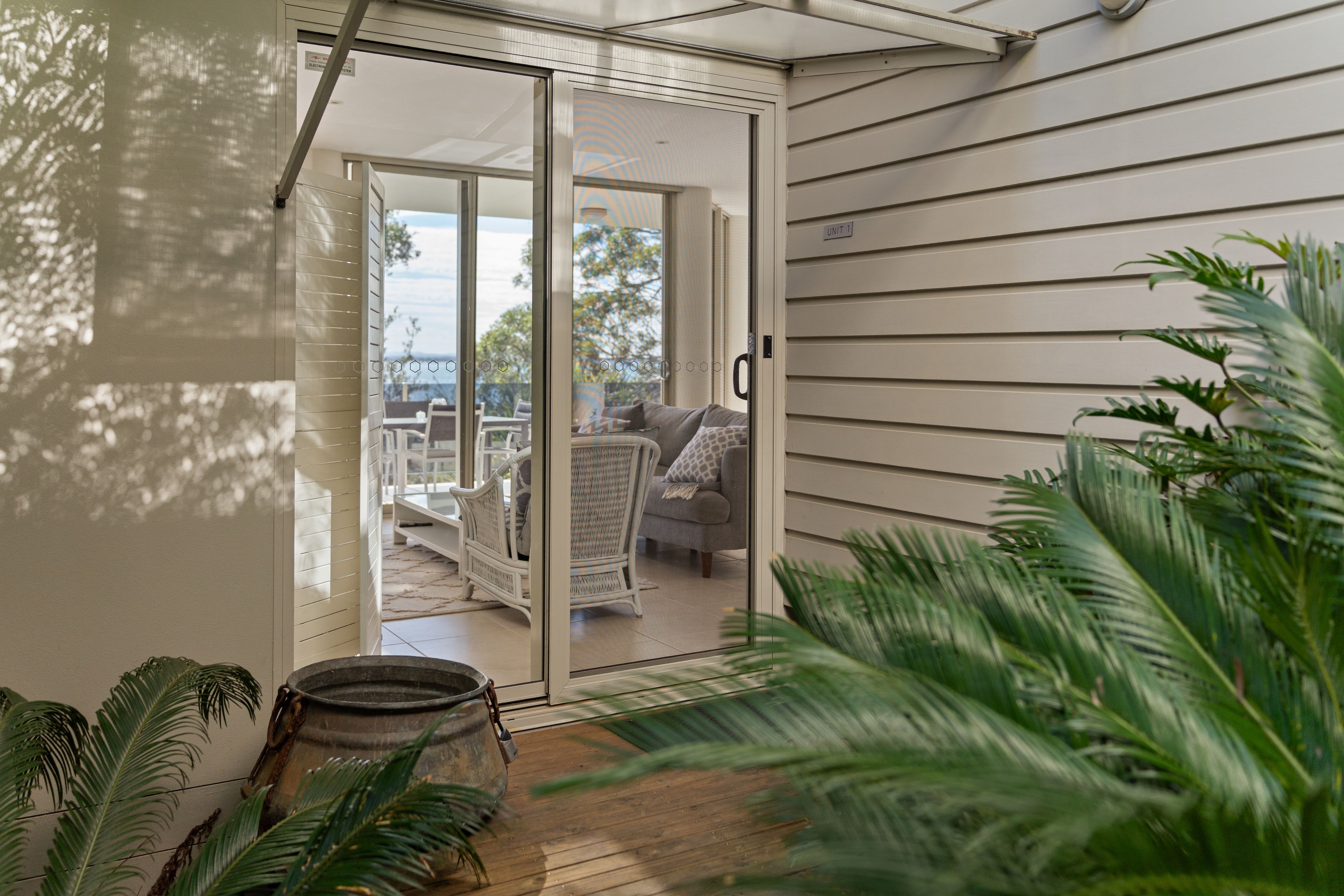 A modern interior with a sliding glass door leading to an outdoor seating area.