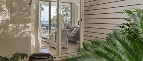 A modern interior with a sliding glass door leading to an outdoor seating area.