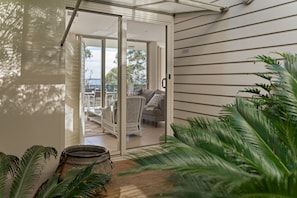 A modern interior with a sliding glass door leading to an outdoor seating area.