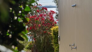 Une vue d’un jardin avec un plan d’eau et des montagnes en arrière-plan.