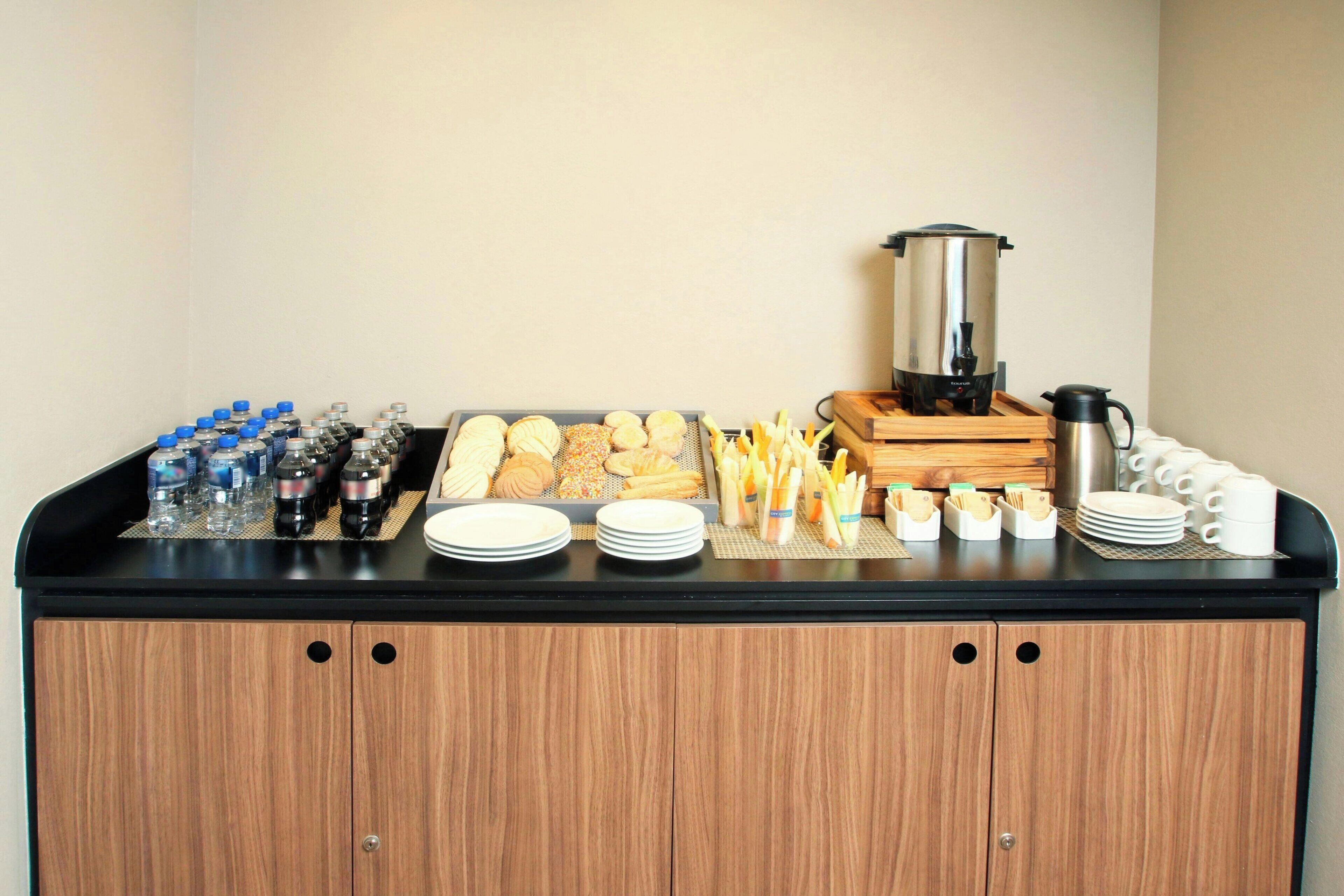 A buffet setup with various food items, beverages, and a coffee station.
