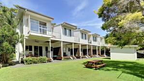 A two-story house with a covered porch and a picnic table in the yard. - Florida Shoal Bay Townhouse near Beach (Shoal Bay)