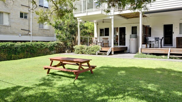 A residential property with a covered patio, a wooden table, and a lawn. - Florida Shoal Bay Townhouse near Beach (Shoal Bay)