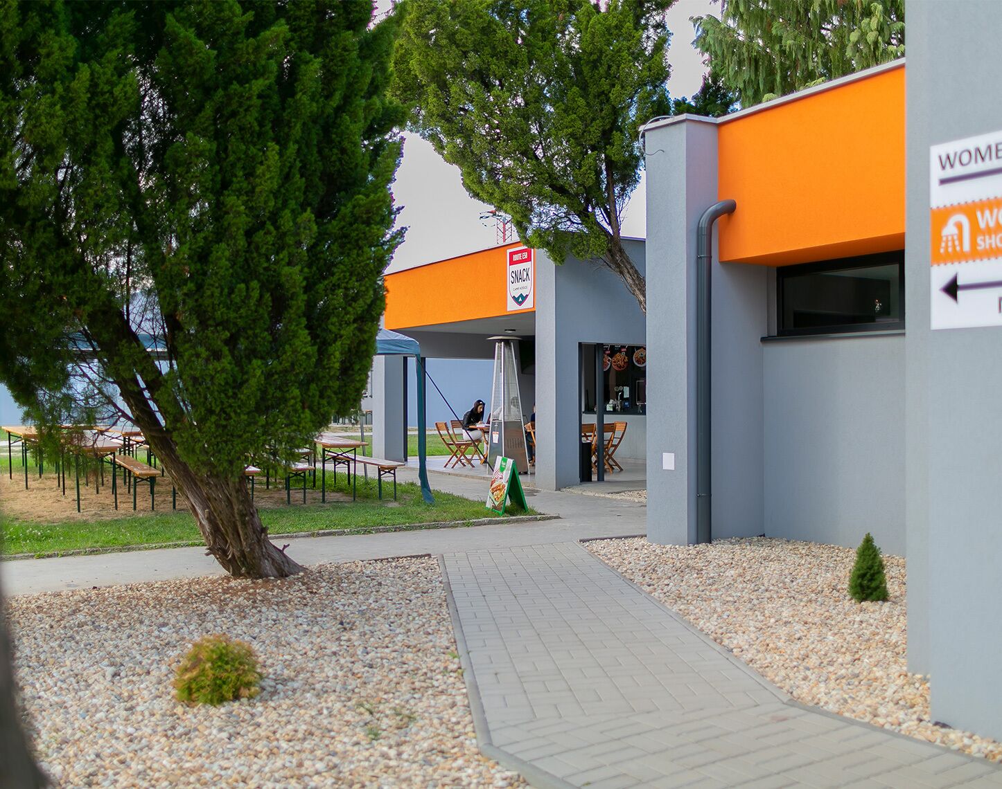 A building with a sign indicating a women's restroom and a snack bar.