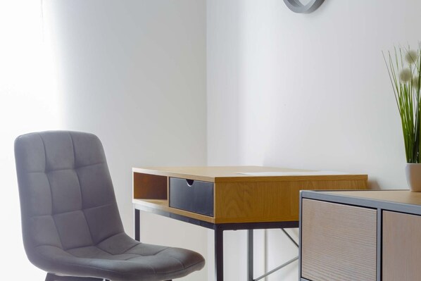 A modern office chair, a wooden desk with a drawer, and a potted plant. - Hotel & Restaurant Resort Barca - Campsite (Kosice)