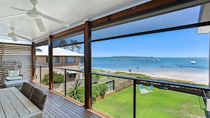 Enjoy the ocean view from this balcony with a table and chairs, perfect for taking in the sights of the pier and boats.