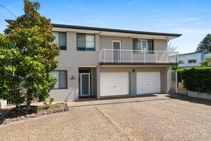 A two-story building with a balcony, a garage, and a driveway. - Waterfront at Sunset Boulevard, 26 Sunset Boulevard (Soldiers Point)