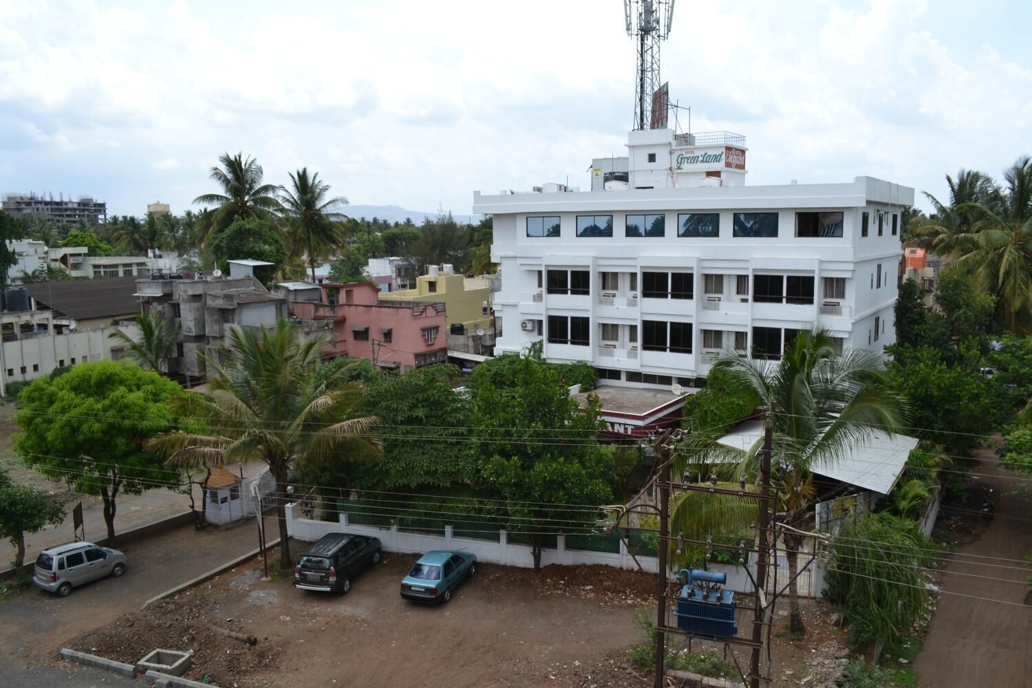 A multi-story building with a flat roof and several air conditioning units.